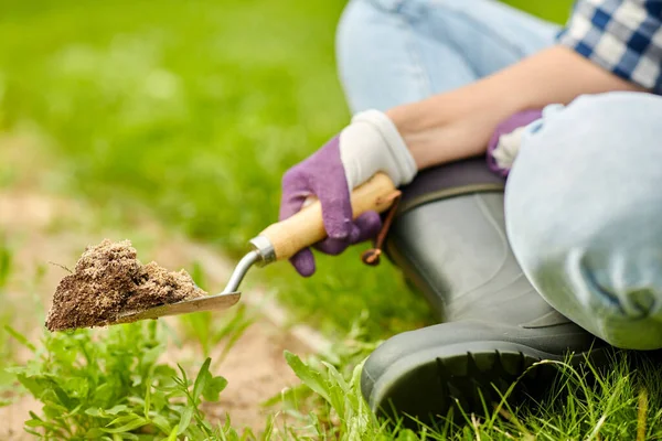 Hand digging flowerbed ground with garden trowel — Stock Photo, Image