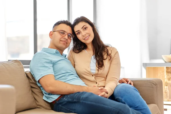 Casal feliz sentado no sofá em casa — Fotografia de Stock