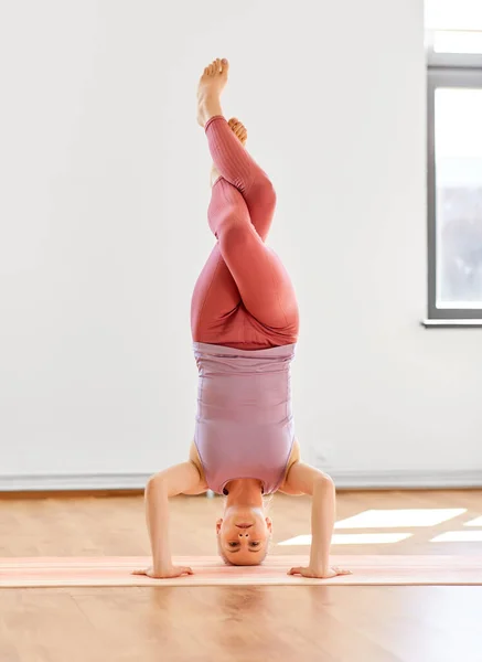 Vrouw doet ondersteunde headstand in yoga studio — Stockfoto