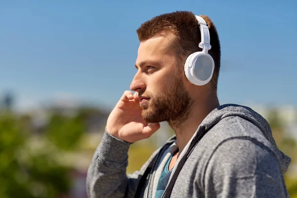 Muž ve sluchátkách poslech hudby venku — Stock fotografie
