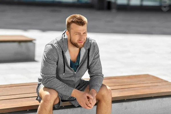 Jonge man zittend op bank buiten — Stockfoto