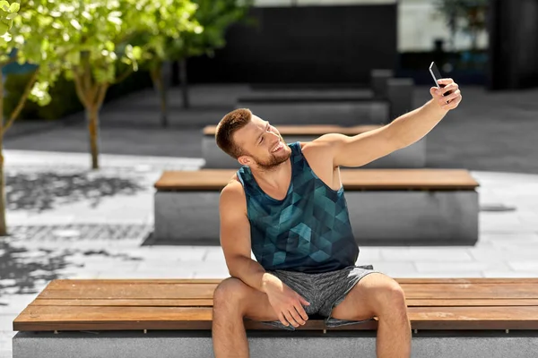 Мужчина делает селфи со смартфоном на улице — стоковое фото