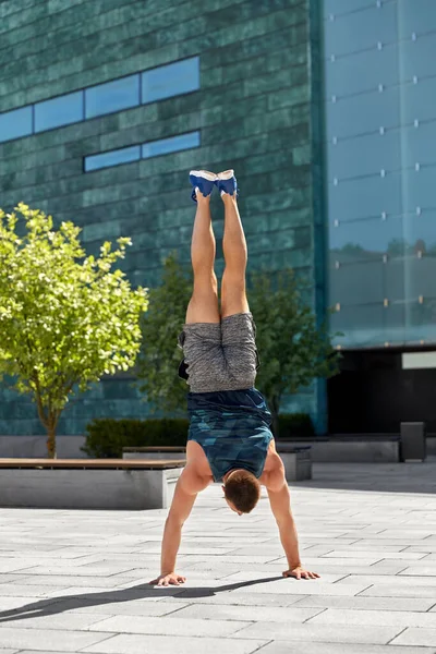 Jeune homme exerçant et faisant handstand à l'extérieur — Photo