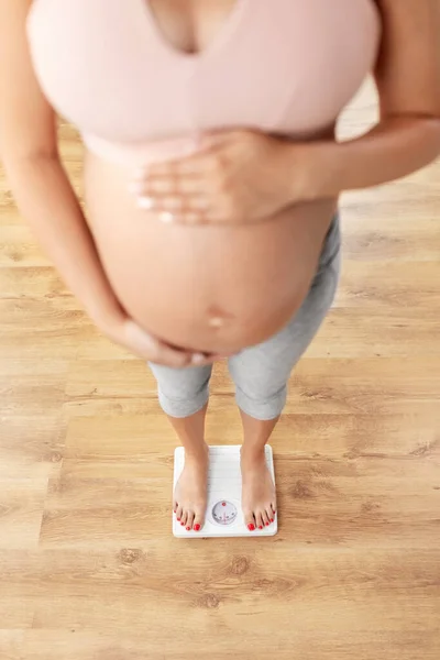 Gravid kvinna stående på våg hemma — Stockfoto