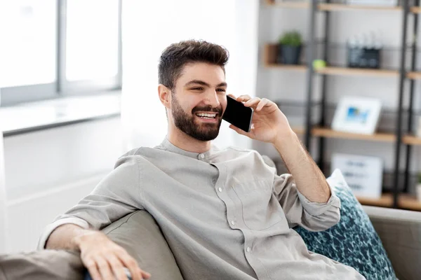 Homem feliz chamando no smartphone em casa — Fotografia de Stock