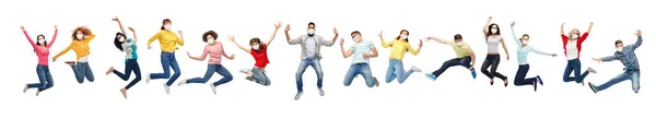 People in face protective masks jumping in air — Stock Photo, Image
