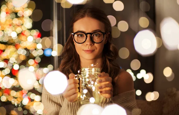 玻璃杯中装有圣诞花环灯的女人 — 图库照片