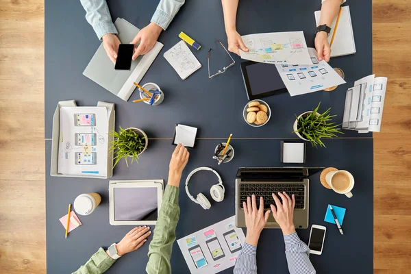 Team di lavoro con gadget che lavorano al tavolo dell'ufficio — Foto Stock