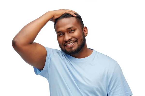 Lächelnder junger afrikanisch-amerikanischer Mann, der Haare berührt — Stockfoto