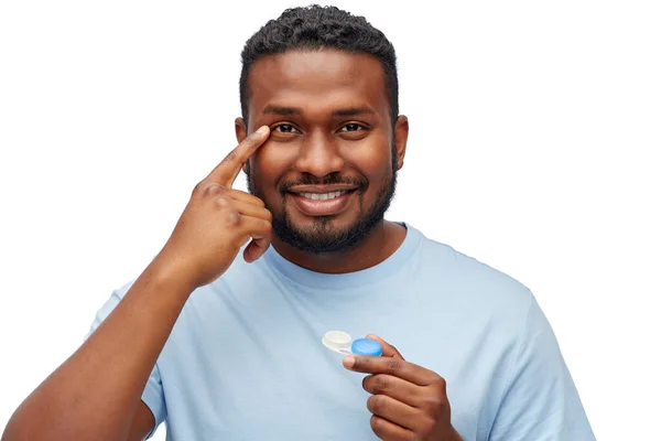 Молодий афроамериканський чоловік застосовує контактні лінзи — стокове фото