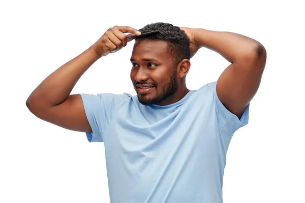 Feliz afro-americano homem escovar o cabelo com pente — Fotografia de Stock