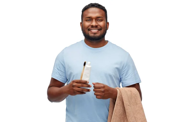 Uomo sorridente con spazzolino, dentifricio e asciugamano — Foto Stock