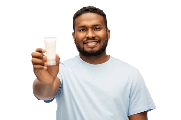 Homem americano africano feliz mostrando hidratante — Fotografia de Stock