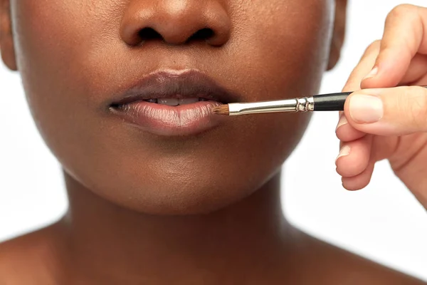 Rosto de mulher africana e mão com maquiagem escova — Fotografia de Stock