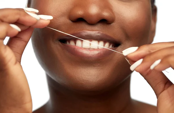 Afrikalı kadın diş ipiyle diş temizliği yapıyor. — Stok fotoğraf