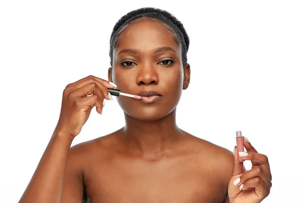 Mulher americana africana aplicando gloss labial — Fotografia de Stock