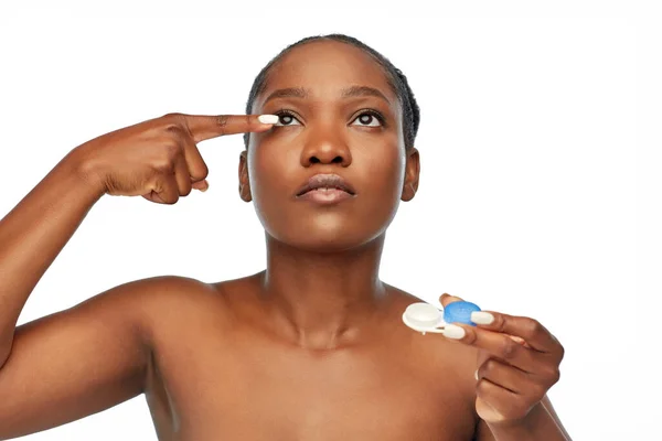African american woman putting on contact lenses Stock Photo