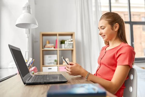 Menina com smartphone distraindo de lição de casa — Fotografia de Stock