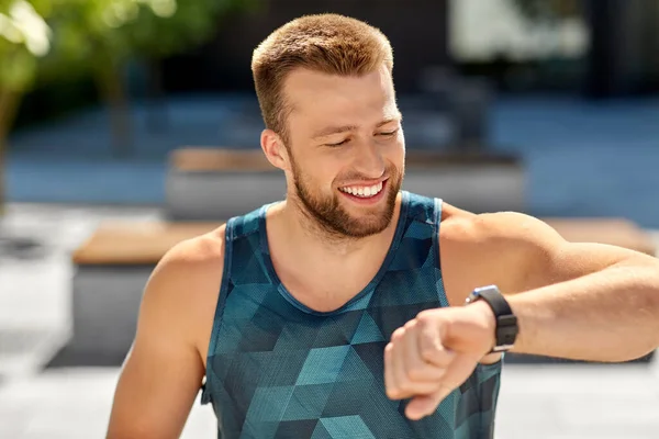 Happy man with fitness tracker in city — Stock Photo, Image