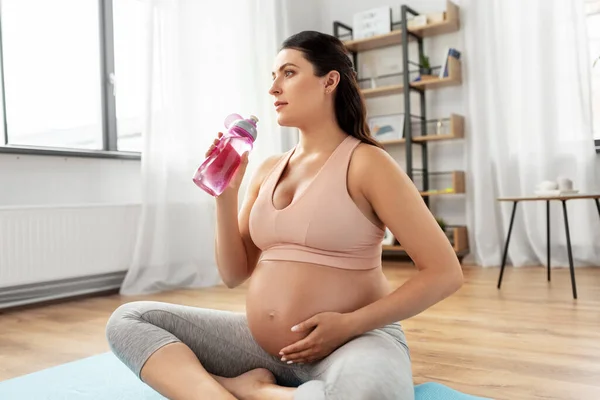 Pregnant woman drinking water after yoga at home — Stock Photo, Image