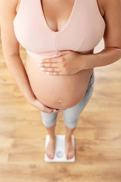Nahaufnahme einer Schwangeren, die auf einer Waage steht — Stockfoto