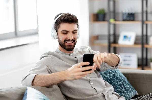 Homem em fones de ouvido ouvir música no smartphone — Fotografia de Stock