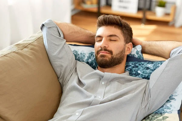 Молодой человек спит дома на диване — стоковое фото