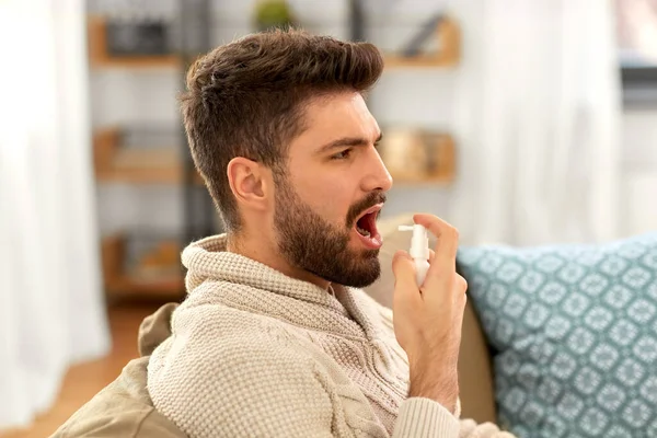 Malato indiano uomo utilizzando spray orale a casa — Foto Stock