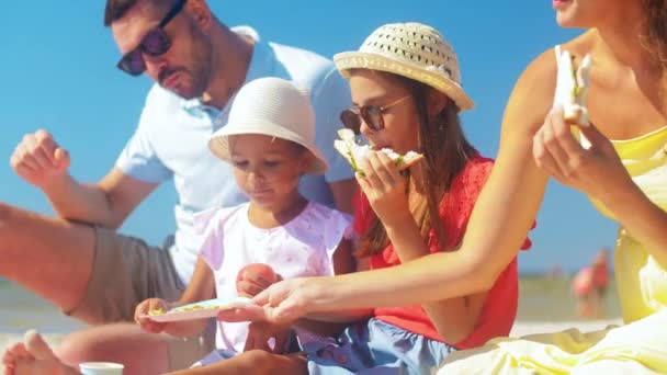 Счастливая семья, устраивающая пикник на летнем пляже — стоковое видео