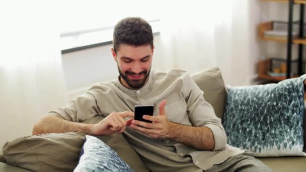 Ευτυχισμένος άνθρωπος με smartphone στο σπίτι — Αρχείο Βίντεο