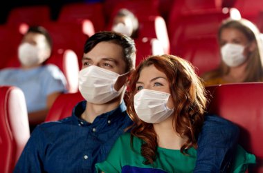 couple in masks watching movie in theater clipart