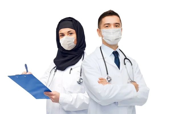 Doctors in masks with clipboard and stethoscope — Stock Photo, Image