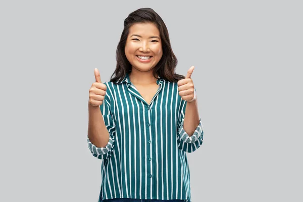 회색 위에 엄지손가락을 보이는 행복 한 동양 여성 — 스톡 사진