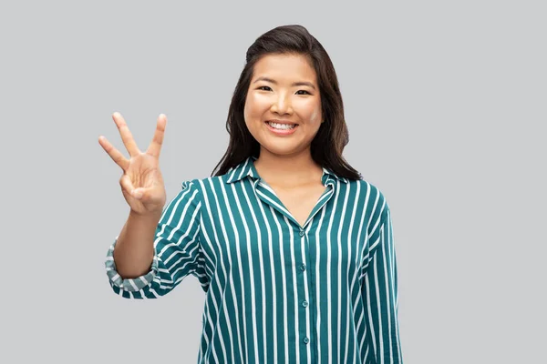 Feliz asiático mujer mostrando tres dedos — Foto de Stock