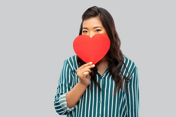 Feliz asiático mujer cubierta cara con rojo corazón — Foto de Stock