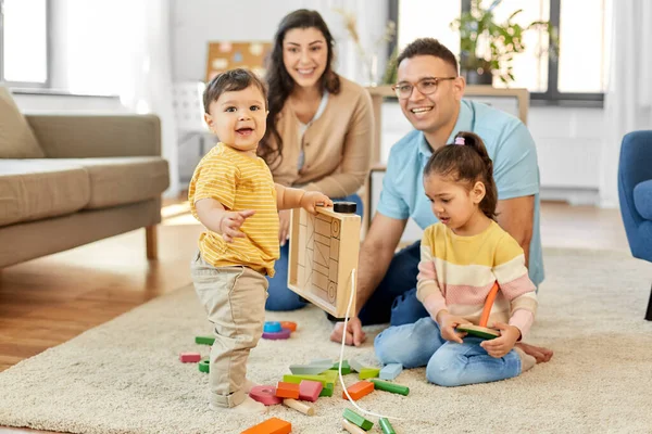 Familia feliz palying con juguetes de madera en casa — Foto de Stock