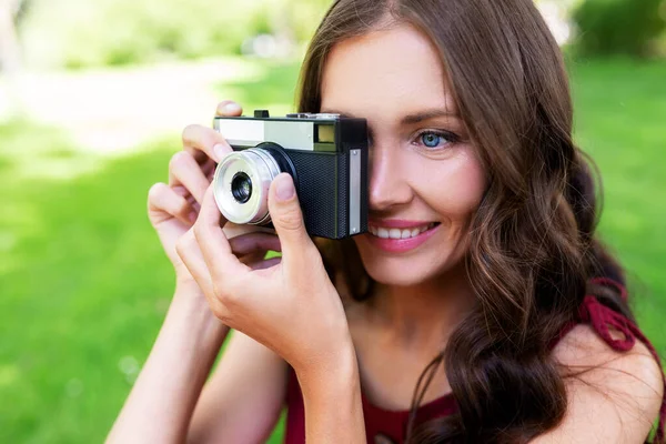 Szczęśliwa kobieta z aparatem fotograficznym w parku — Zdjęcie stockowe