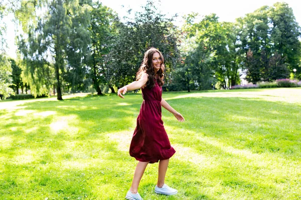 Gelukkig glimlachende vrouw wandelen langs zomerpark — Stockfoto