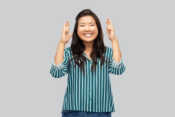 Glad leende asiatisk kvinna håller fingrarna korsade — Stockfoto