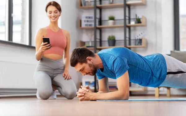 Feliz pareja haciendo ejercicio en casa —  Fotos de Stock