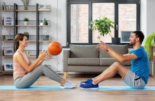 Feliz casal exercitando com bola em casa — Fotografia de Stock