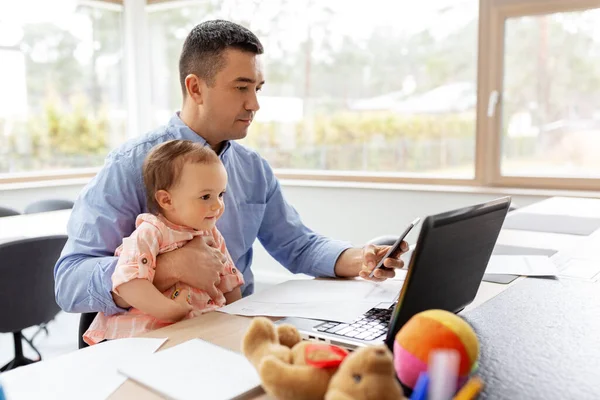 Vader met baby en smartphone thuis werken — Stockfoto