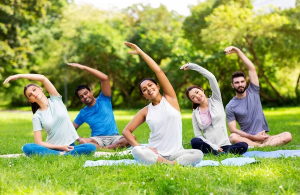 Grupp människor motionerar på sommarparken — Stockfoto