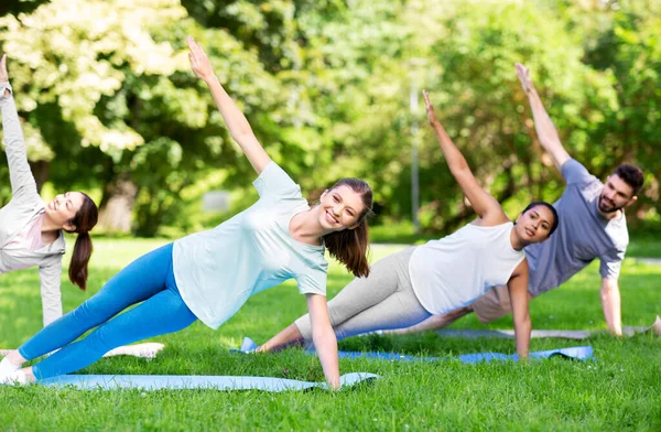 Groep mensen die yoga doen in het zomerpark — Stockfoto