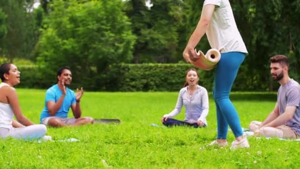 Skupina lidí se schází na hodinu jógy v parku — Stock video