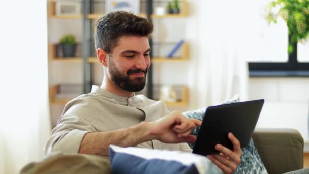 Hombre sonriente con Tablet PC en casa — Vídeos de Stock