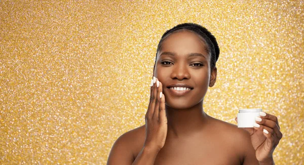 Femme afro-américaine souriante avec hydratant — Photo