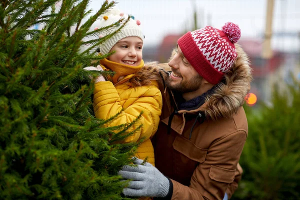 幸せな家族は市場でクリスマスツリーを選ぶ — ストック写真