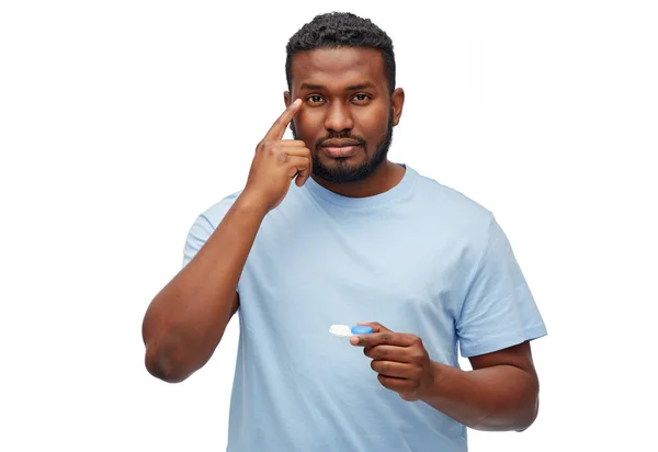 Giovane uomo afro-americano che applica lenti a contatto — Foto Stock