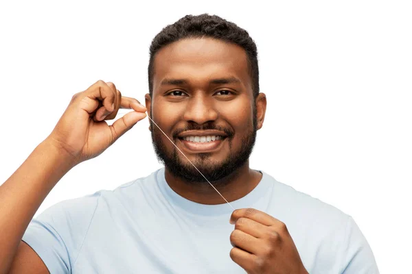 牙线清洁牙齿的快乐的非洲男人 — 图库照片